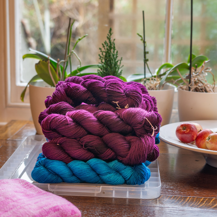 Skeins of wool on a table with window behind