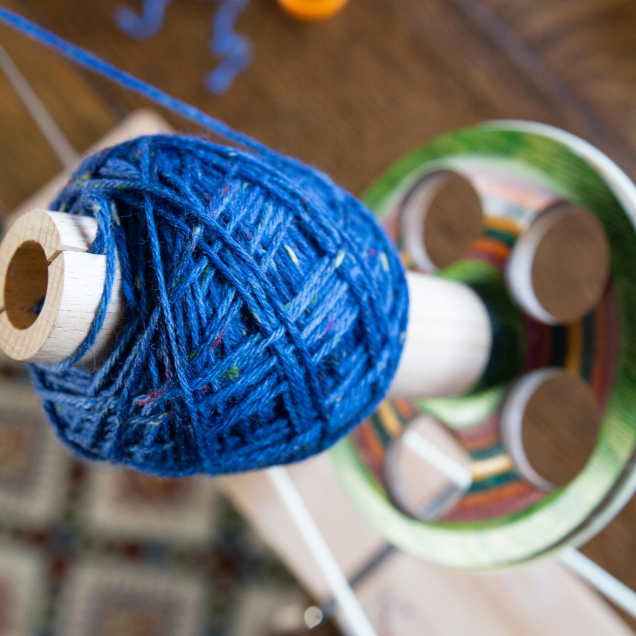 Winding a ball of blue tweed yarn