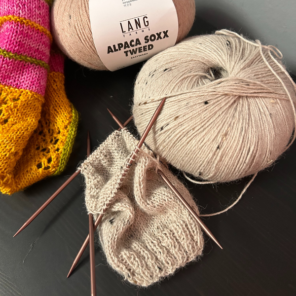 Knitted socks in ALPACA SOXX TWEED laid flat to display stitch definition and colour flecks