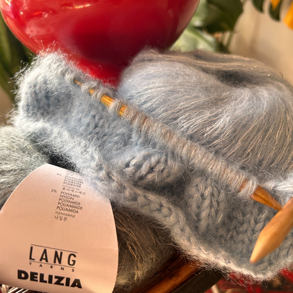Close-up of knitted fabric in DELIZIA, highlighting airy texture and gentle metallic sparkle