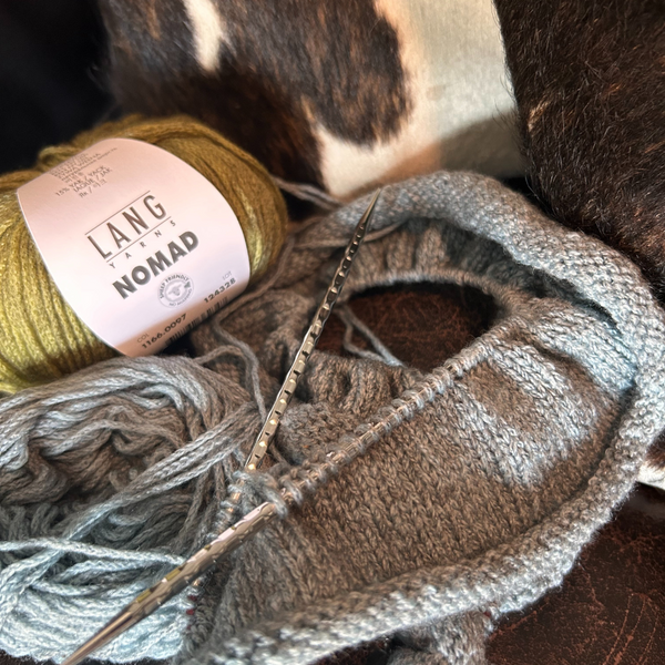 Close-up of NOMAD yarn ball showing subtle grey-brown heathering